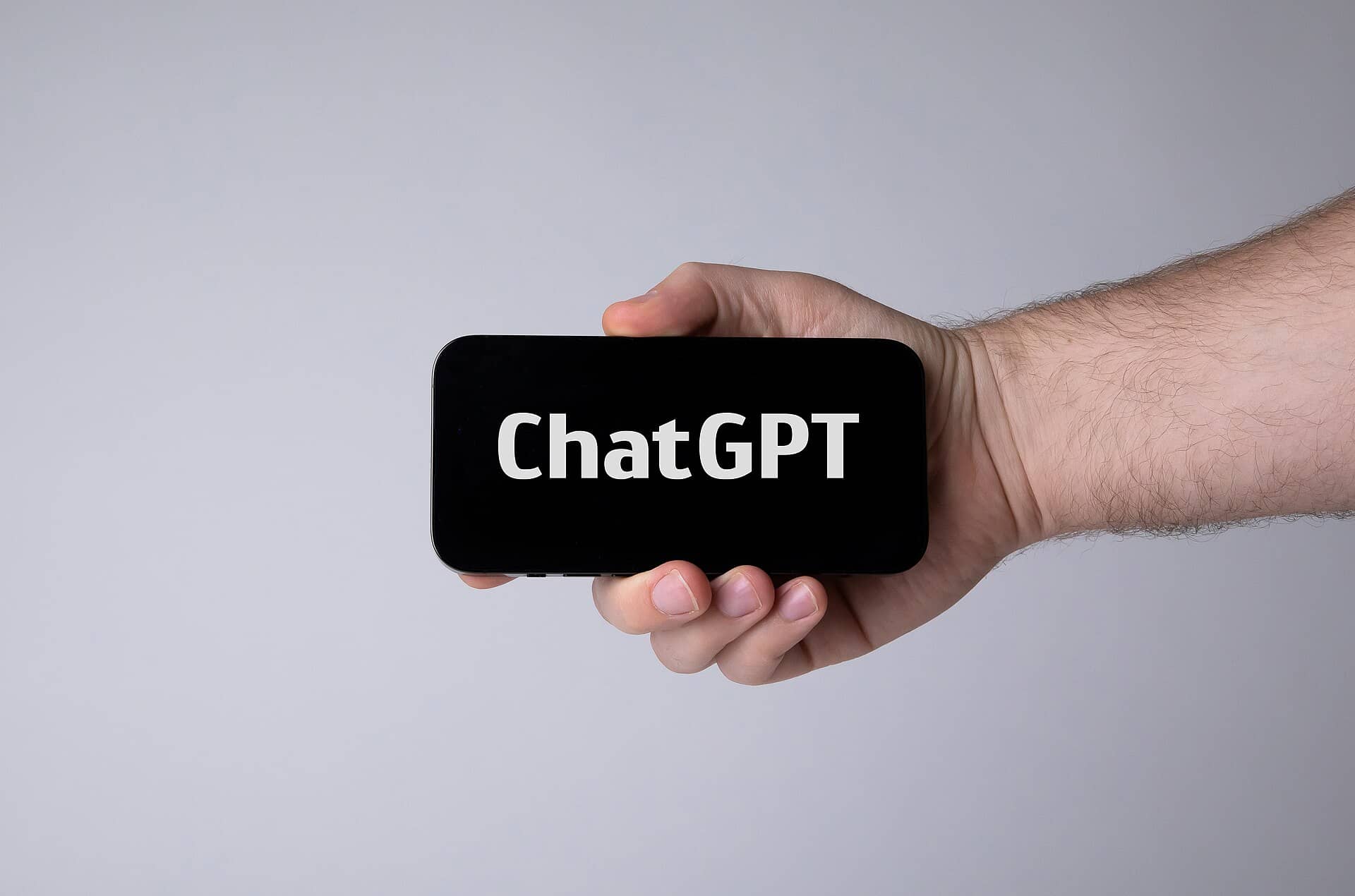 Mão segurando um celular com o ChatGPT aberto na tela