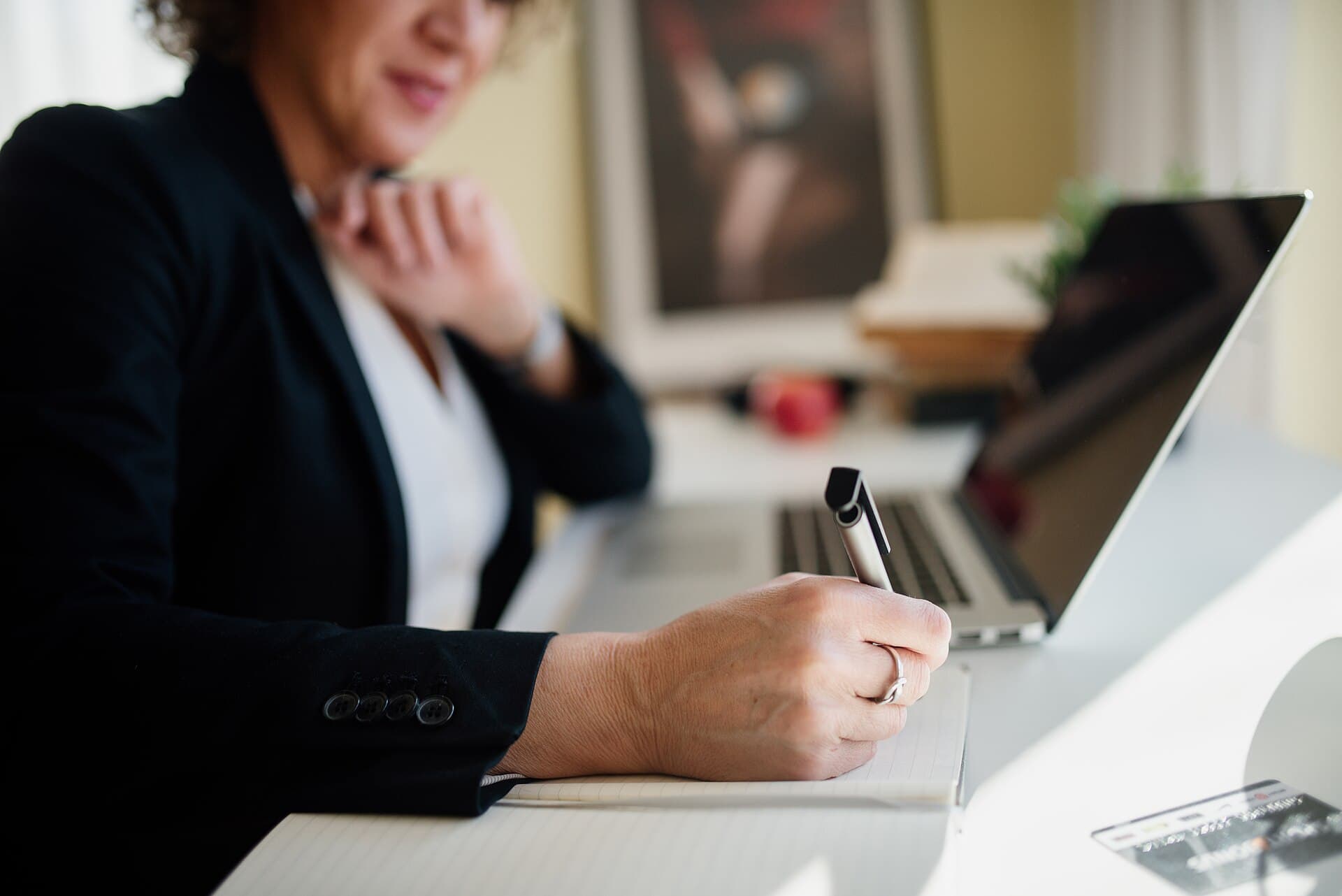 Profissional fazendo anotações em uma reunião em uma mesa de escritório moderna
